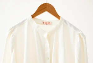 una camicia di cotone appesa su un appendino di legno, blouse di cotone